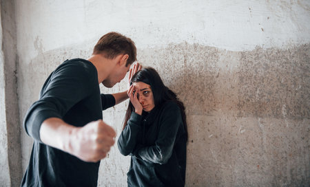 Kidnapped woman is threatened by man in abandoned buildingの写真素材