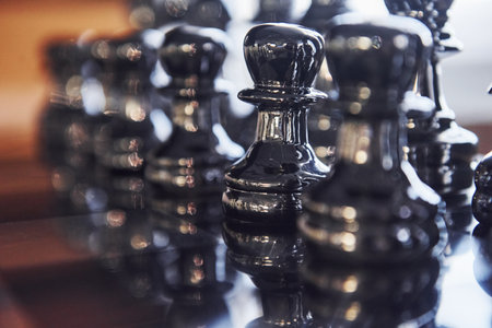 Chess board with metal figures on it indoors on the table at daytimeの写真素材