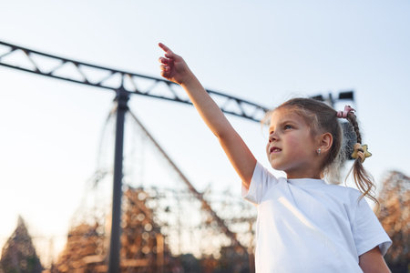 Little girl have fun at childrens amusement park at daytimeの写真素材