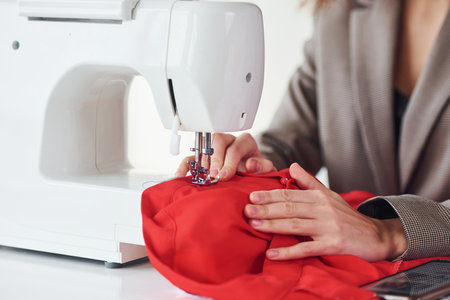 Seamstress working in the office. Young woman in formal clothes is indoors. Conception of styleの写真素材