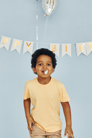 Happy little african american kid have fun indoors at birthday partyの写真素材