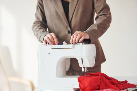 Seamstress working in the office. Young woman in formal clothes is indoors. Conception of styleの写真素材