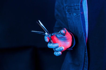 Close up view of barbers hands that holding scissors. Neon lightingの写真素材