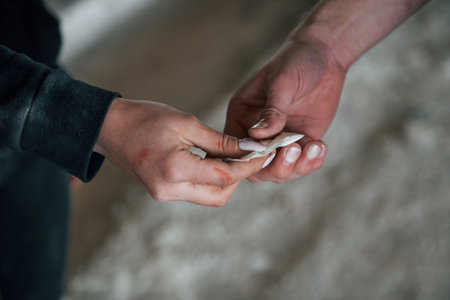 Selling and buying illegal drugs. Close up view of mans and womans hands with packageの写真素材