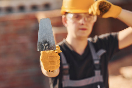Portrait of construction worker in uniform and safety equipment that standing on buildingの写真素材