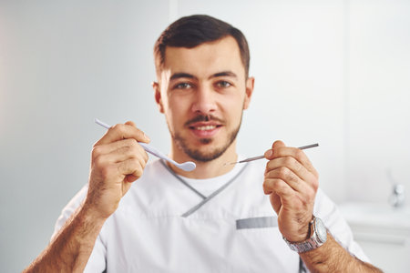 Portrait of professional dentist with equipment that standing indoorsの写真素材