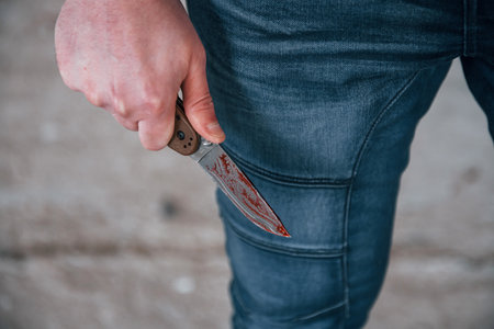 Close up view of killer that standing with knive with blood in handの写真素材