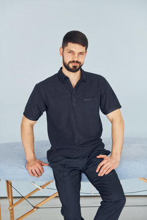 Serious man in shirt standing indoors against white backgroundの写真素材