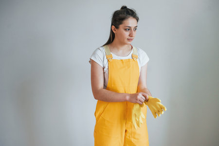 Housewife in yellow uniform preparing for polishing windows indoors. House renovation conceptionの写真素材