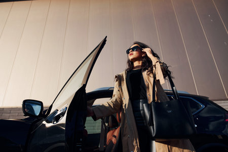 Young woman in black leggins walks out from her modern carの写真素材
