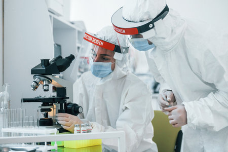 Female medical workers in protective uniform works on COVID-19 vaccineの写真素材
