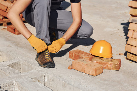 Close up view of construction worker in uniform and safety equipment preparing for the job