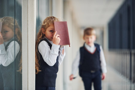 School kids in uniform with books together in corridor. Conception of educationの写真素材