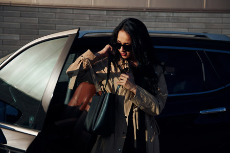 Young woman in black leggins walks out from her modern carの写真素材
