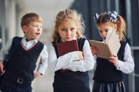 School kids in uniform together with books in corridor. Conception of educationの写真素材