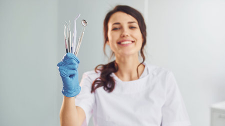 Portrait of professional female dentist with equipment that standing indoorsの写真素材