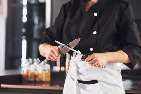 Professional young chef cook in uniform standing and preparing for the work on kitchenの写真素材