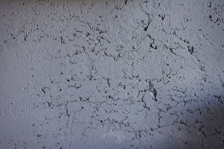 Background of grey wall with modern design of cracks. Indoors at homeの写真素材