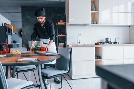 Professional young chef cook in uniform making salad on the kitchenの写真素材