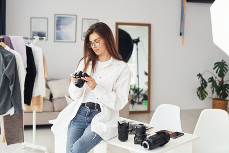Female photographer in casual clothes is working indoors at daytimeの写真素材