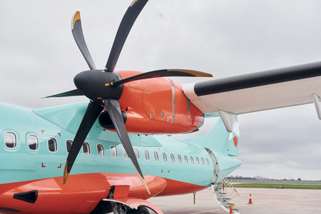 Retro style. Turboprop aircraft parked on the runway at daytime
