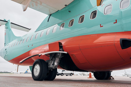 Close up view of wheels. Turboprop aircraft parked on the runway at daytime