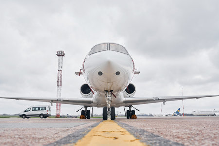 Front view. Turboprop aircraft parked on the runway at daytimeの写真素材