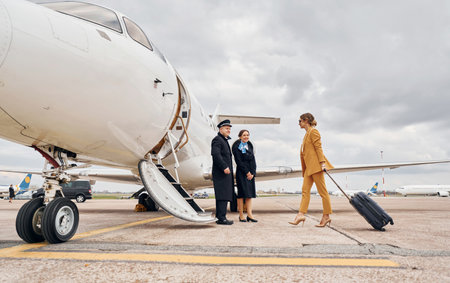 Airplane crew leads woman in yellow clothes inside of a planeの写真素材