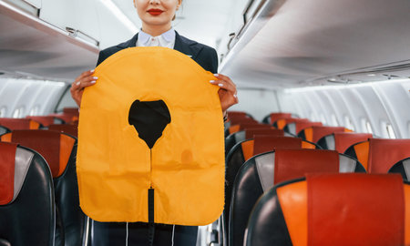 Safety instructions. Young stewardess on the work in the passanger airplaneの写真素材