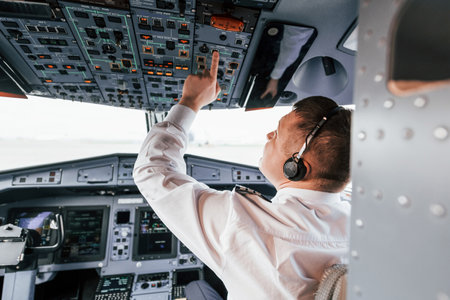 Control of the flight. Pilot on the work in the passenger airplane. Preparing for takeoffの写真素材