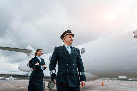 Man with woman. Aircraft crew in work uniform is together outdoors near plane