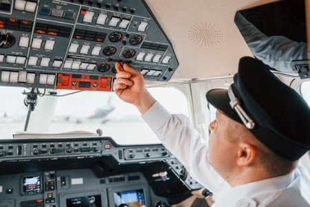 Close up view. Pilot on the work in the passenger airplane. Preparing for takeoffの写真素材