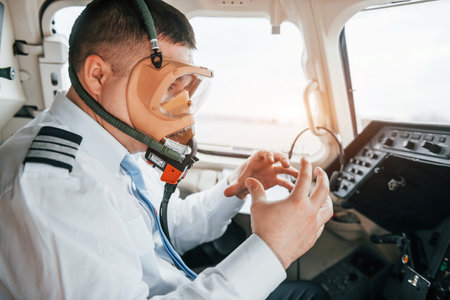 In oxygen mask. Pilot on the work in the passenger airplane. Preparing for takeoffの写真素材