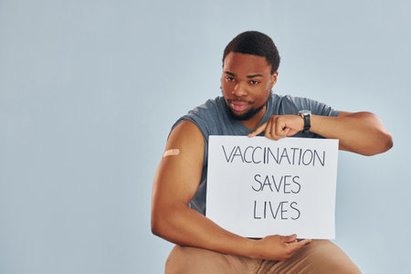 Vaccination saves lives banner. Young african american man after vaccine injectionの写真素材