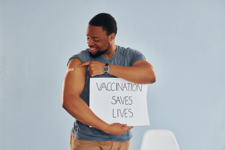 Vaccination saves lives banner. Young african american man after vaccine injection