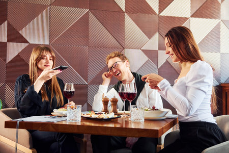 Young couple and mother. Indoors of new modern luxury restaurantの写真素材