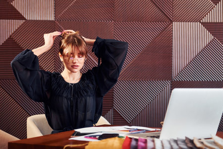 Woman sits by table with laptop and documents. Indoors of new modern luxury restaurantの写真素材
