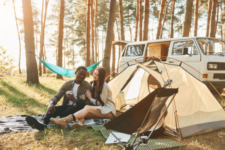 Warm weather. Young couple is traveling in the forest at daytime togetherの写真素材
