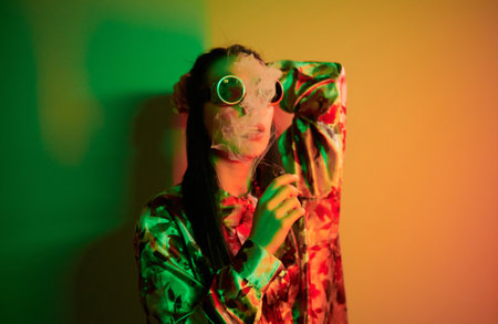 In retro pilot glasses. Fashionable young woman standing in the studio with neon lightの写真素材