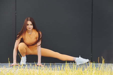 Stretching exercises. Young woman in sportswear have fitness session outdoorsの写真素材