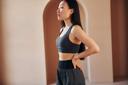 Young serious asian woman standing indoorsの写真素材