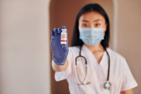 COVID-19 vaccine. Young serious asian woman standing indoorsの写真素材