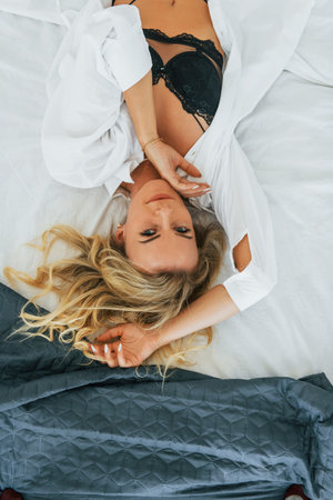 In sexy underwear. Woman in casual clothes is indoors at homeの写真素材