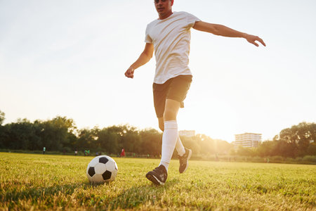 Runs with ball. Young soccer player have training on the sportive fieldの写真素材
