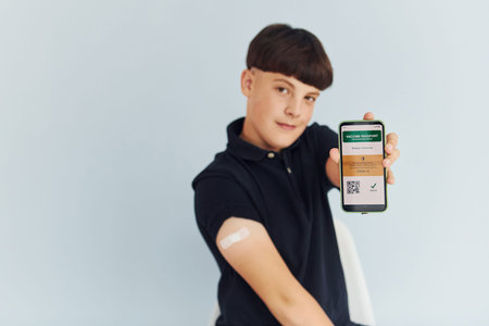 Portrait of young boy in black shirt that sitting after vaccinationの写真素材