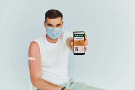 Young man in white shirt is indoors against white backgroundの写真素材