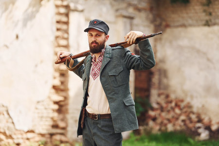 TERNOPIL, UKRAINE - June 2020 UPA Ukrainian Insurgent Army movie filming. Pictures of backstage. Young soldier with weapon near old buildingのeditorial素材