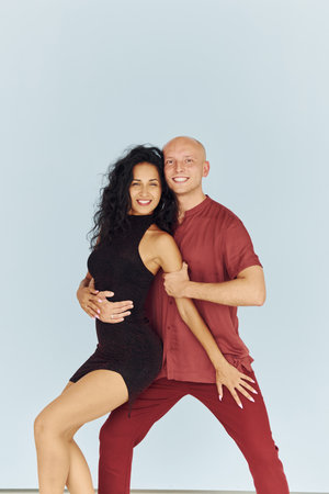 In black and red clothes. Cheerful couple is together indoorsの写真素材