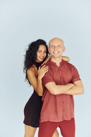 Standing in the studio against white background. Cheerful couple is together indoors