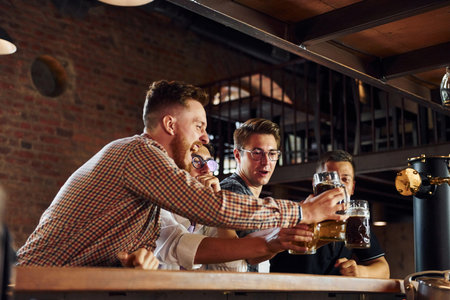 Positive friends. People in casual clothes sitting in the pubの写真素材